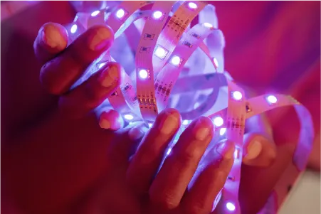 manos sosteniendo una tira de luces led color morada